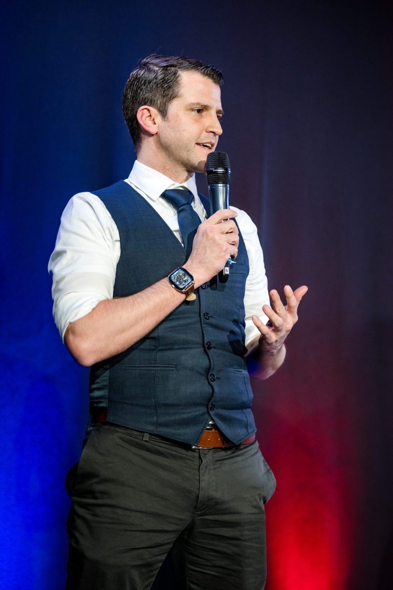 Roger Basler de Roca on stage mit mikrofon in Hand
